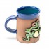 Blaue Keramiktasse mit winkendem Frosch